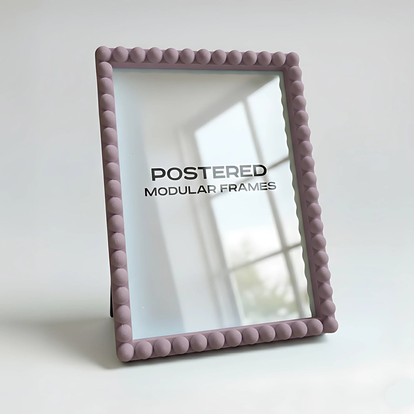 Pink textured picture frame with 'POSTERED MODULAR FRAMES' branding on a light background