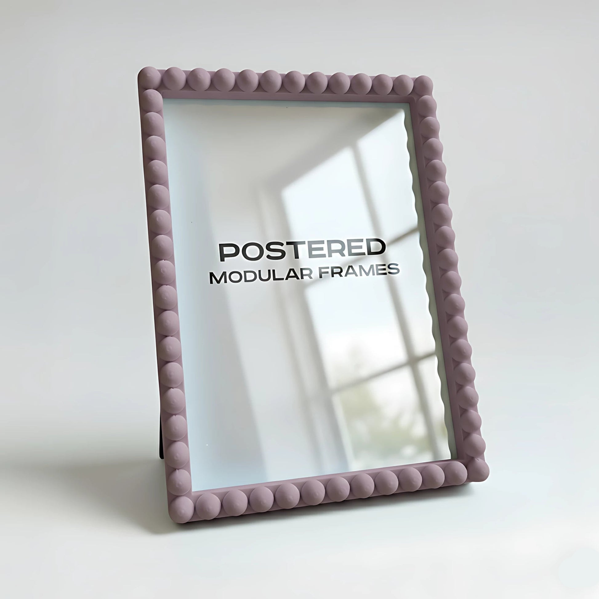 Pink textured picture frame with 'POSTERED MODULAR FRAMES' branding on a light background