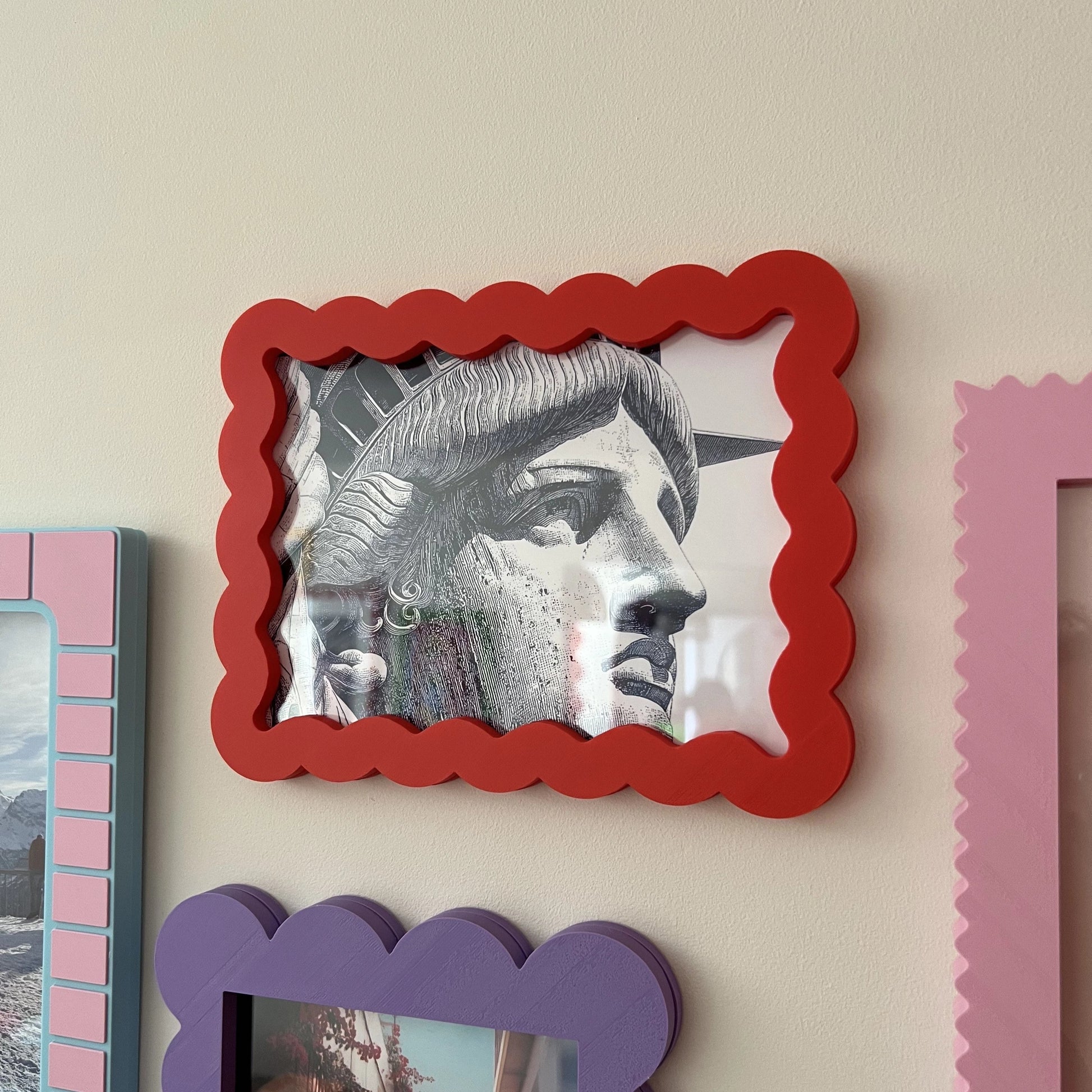 Decorative picture frames on a wall with a focus on a red frame.