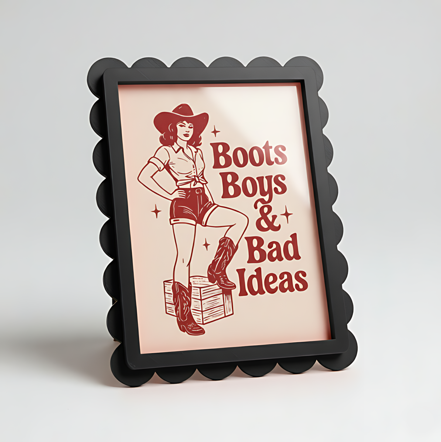 Framed poster with a graphic of a woman in a cowboy hat and boots with text 'Boots Boys & Bad Ideas' on a light background.