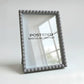 Gray textured picture frame with 'POSTERED MODULAR FRAMES' branding on a light background