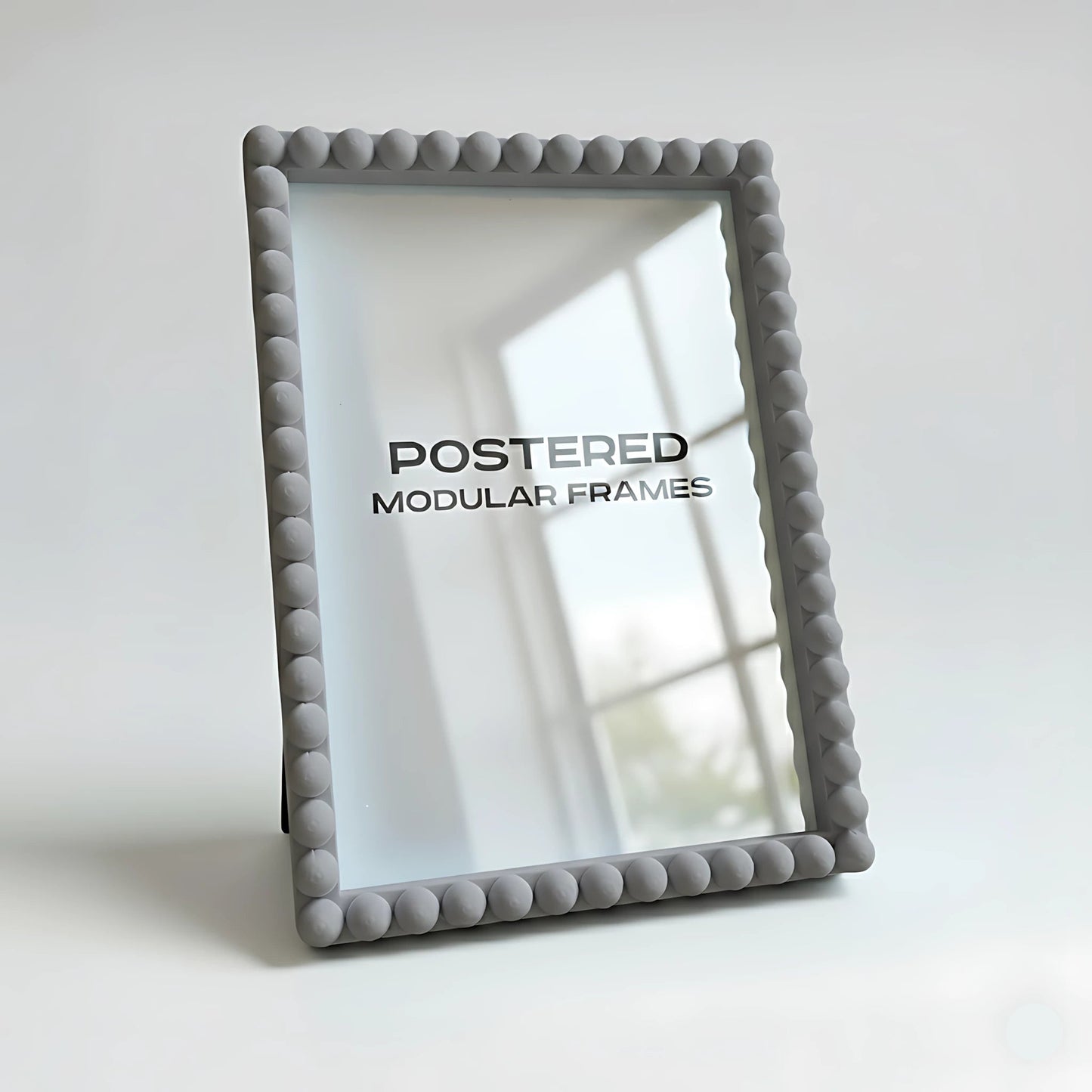 Gray textured picture frame with 'POSTERED MODULAR FRAMES' branding on a light background