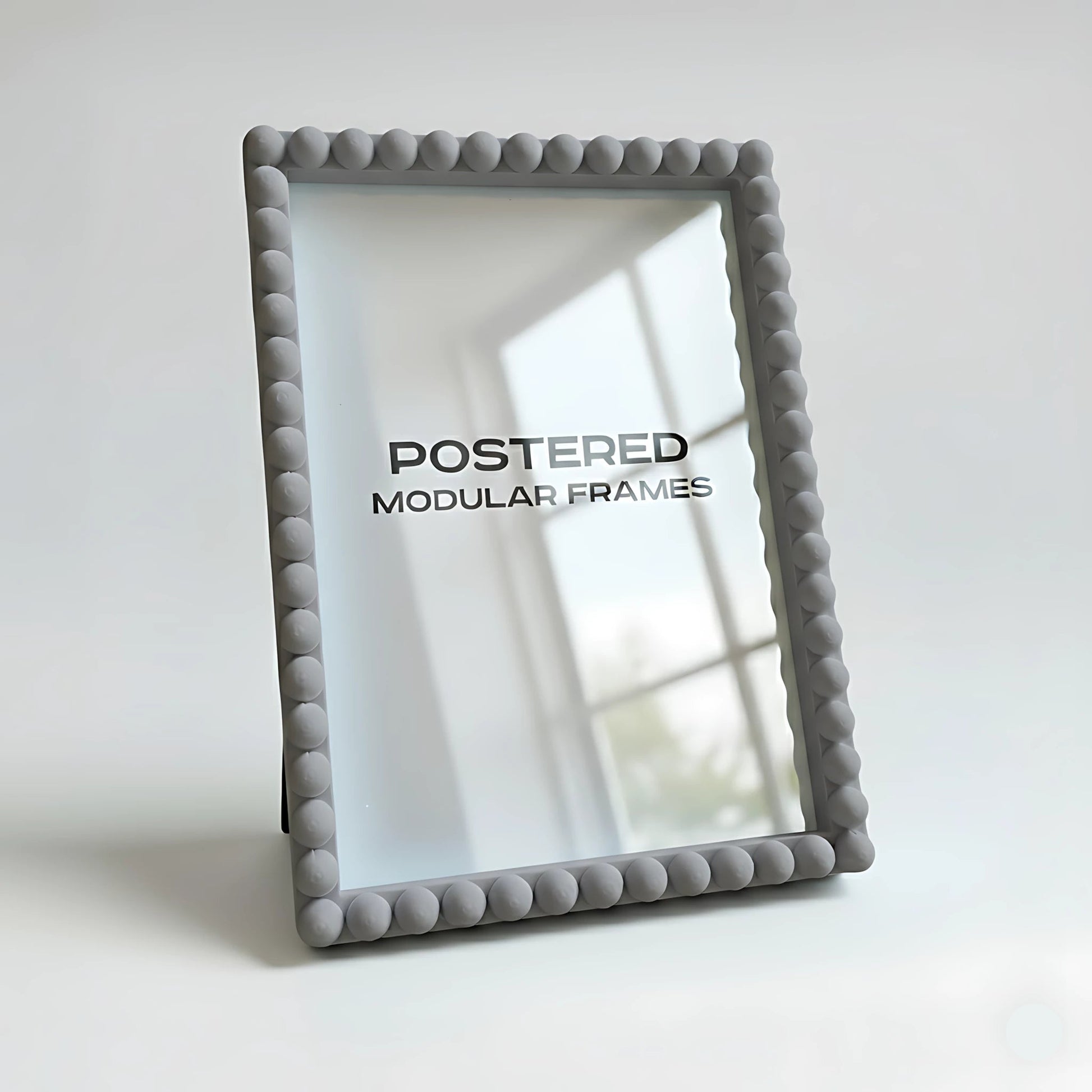 Gray textured picture frame with 'POSTERED MODULAR FRAMES' branding on a light background